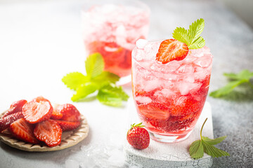 Refreshing summer drink with strawberry slices in glasses on white background