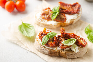 Bruschetta with sundried tomatoes, cottage cheese and fresh basil. Tasty savory Italian appetizers