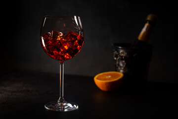 Aperol spritz cocktail in glass with fresh orange on dark background