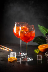 Aperol spritz cocktail in glass with fresh orange on dark background