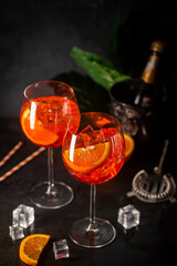 Aperol spritz cocktail in glass with fresh orange on dark background