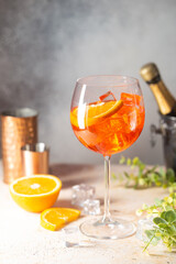 Aperol spritz cocktail in glass with fresh orange on gray background