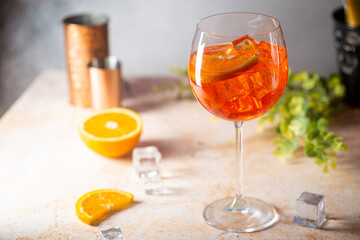 Aperol spritz cocktail in glass with fresh orange on gray background