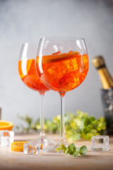 Aperol spritz cocktail in glass with fresh orange on light background