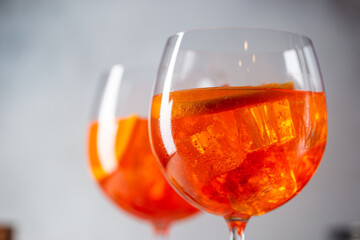 Aperol spritz cocktail in glass with fresh orange on light background