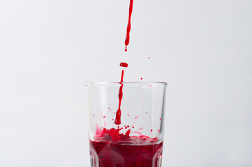 Grape and pomegranate juice pouring into a glass, isolate on a white background