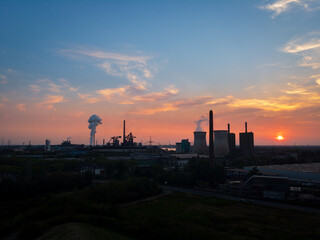 Scenic view of industrial landscape power station and cooling tower at sunset against sky.