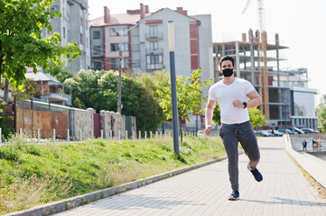 Portrait sports arabian man in black medical face mask run outdoor during coronavirus quarantine.