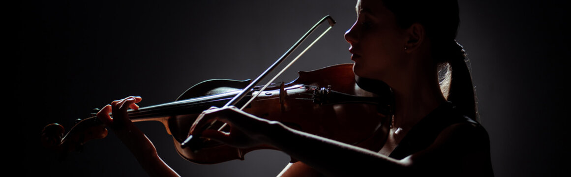 Silhouette Of Female Musician Playing On Violin On Dark Stage, Panoramic Orientation