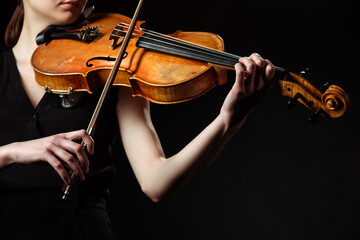 partial view of female musician playing symphony on violin isolated on black