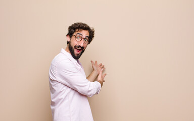 young cool bearded man expressing a concept against flat wall