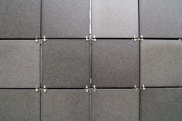 The texture of the wall is made up of a pattern of gray tiles under the granite with intersperses...