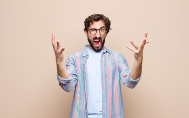 young bearded man against flat wall