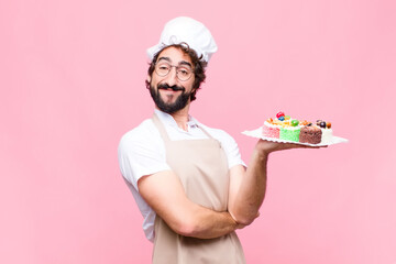 young crazy baker man confectionery concept against pink wall