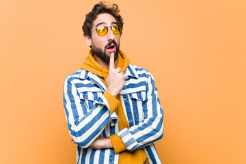 young crazy cool man thinking against flat wall