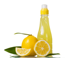 Bottle of lemon juice and fresh lemons with green leavs. Isolated on white.