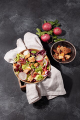 Traditional Middle Eastern Fattoush salad with pita bread,fresh vegetables and lemon sumac dressing on dark gray background top view.Healthy vegetarian food