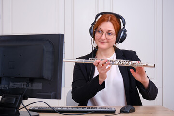 Learning to play musical instruments online. Lessons of playing the flute over the Internet during the outbreak of coronavirus. The musician tells the rules of playing wind musical instruments