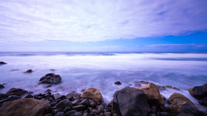 Nice sunset at sea with rocks and clouds