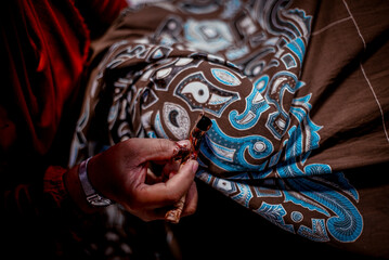 Fototapeta na wymiar Solo Indonesia, June 03 2020 : Traditional canting for making Batik Tulis in Surakarta with background colorful Fabric