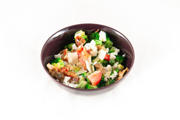 Broccoli Salad with Bacon, parmesan cheese in a black plate. Isolated on white.