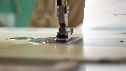 Fototapeta na wymiar Modern sewing clothes machine on a white table