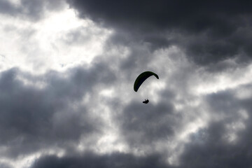 paraglider silhouette in front of a dark cloudy sky