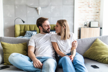 Young in love couple at home relaxing in sofa