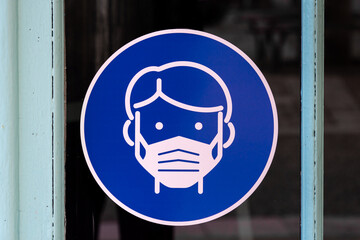 Symbole attention masque obligatoire sur une vitrine