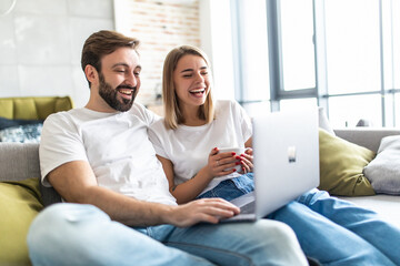 Portrait of a couple using a laptop on the couch