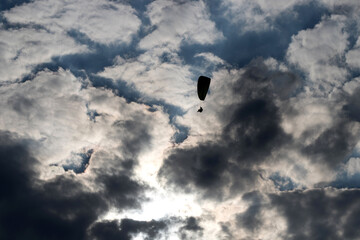 paraglider silhouette in front of a dark cloudy sky