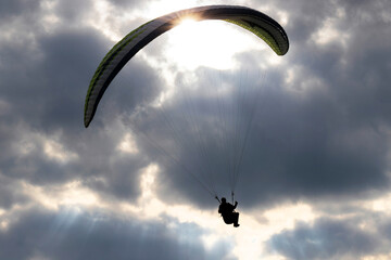 paraglider silhouette in front of a dark cloudy sky