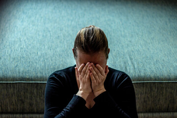 Young woman sad and fear stressful depressed emotional. Stop abusing violence in women. Portrait of a stressful women sitting on the floor with hands on her face.