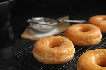 Sweet delicious glazed donuts on black table