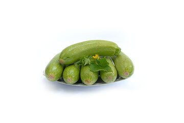 Young fresh green marrows on a plate on a white background