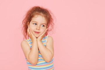 Portrait of surprised cute little toddler girl child over pink background. Looking at camera....