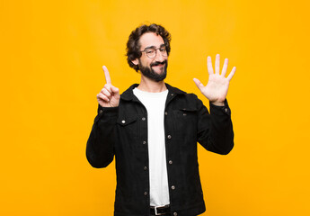young crazy handsome man smiling and looking friendly, showing number six or sixth with hand...