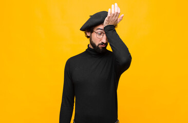 young french artist man raising palm to forehead thinking oops, after making a stupid mistake or...