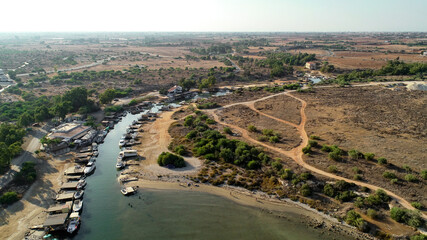 Fototapeta na wymiar Aerial bird's eye view Liopetri river to sea (potamos Liopetriou), Famagusta, Cyprus.Fjord landmark tourist attraction fishing village with colourful boats moored on banks at Kokkinochoria, from above