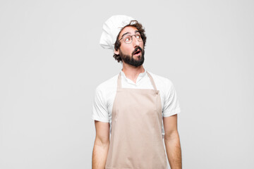 young crazy chef with a worried, confused, clueless expression, looking up to copy space, doubting...