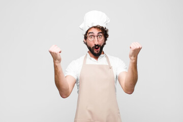 young crazy chef celebrating an unbelievable success like a winner, looking excited and happy...