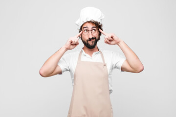 young crazy chef looking concentrated and thinking hard on an idea, imagining a solution to a...