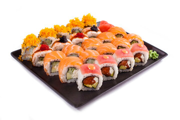 Big sushi set on black plate on white background, copy space
