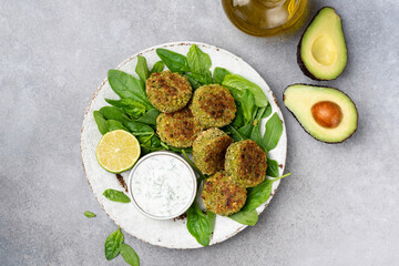 Falafel with yogurt sauce. Vegetarian spinach avocado chickpea fritters Falafel served with yogurt sauce on plate. Top view. Healthy vegetarian food