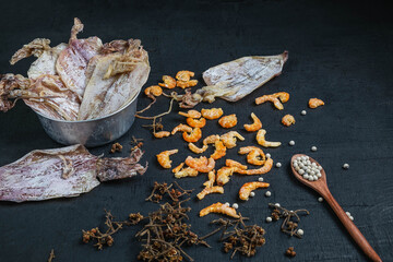 Dried seafood With dried squid and dried shrimp on a black wooden table