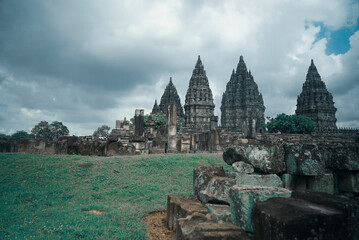 Yogyakarta Indonesia, June 01 2020 : Prambanan temple is a Hindu temple compound included in world heritage list with grass field view. Monumental ancient architecture, carved stone walls.