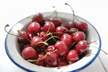 fresh cherries with water drops in a bowl. close up view. poster or summer calendar page. summer antioxidant berries for heart health.