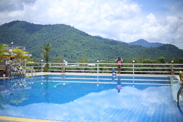 Woman standing at the pool area with mountain views