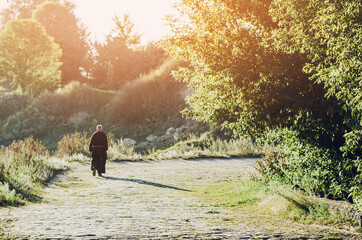 monk of the Capuchin Order, an adult wise man with a beard and in long dark brown clothing walks...