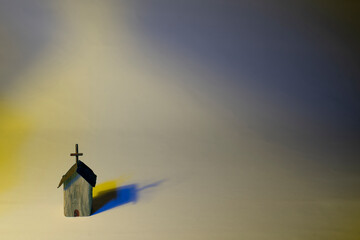 Colorful wooden church with harsh lighting on pastel background. Conceptual about accepting all color